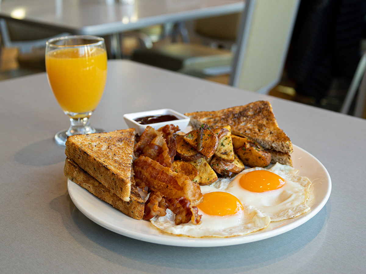 Classic park breakfast with eggs, bacon, potatoes, and toast. Served with an orange juice. 